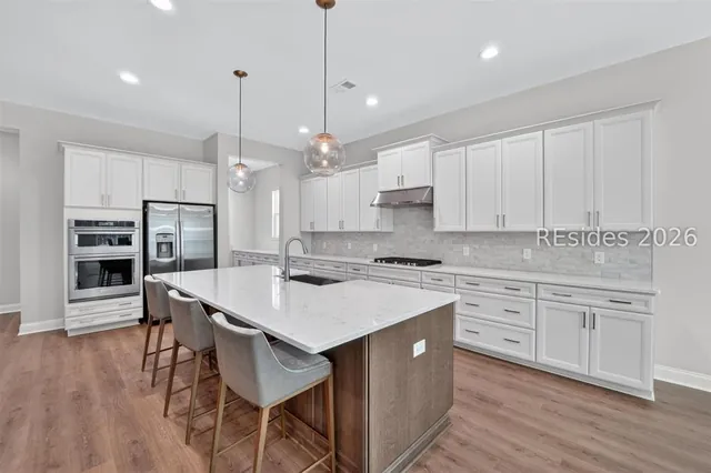 Kitchen with wall ovens and white cabinetry at 1628 Laurel Oak Avenue