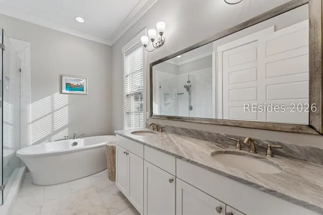 Primary bathroom with freestanding soaking tub and double vanity at 5 Caspian Lane